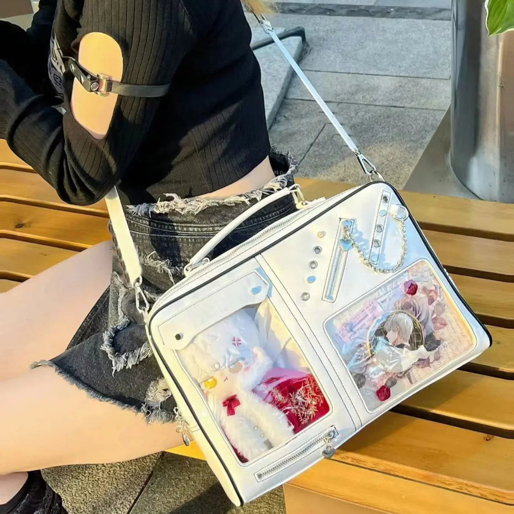A person sitting on a bench with a white Harajuku-style messenger bag featuring transparent panels and decorated with appliques.